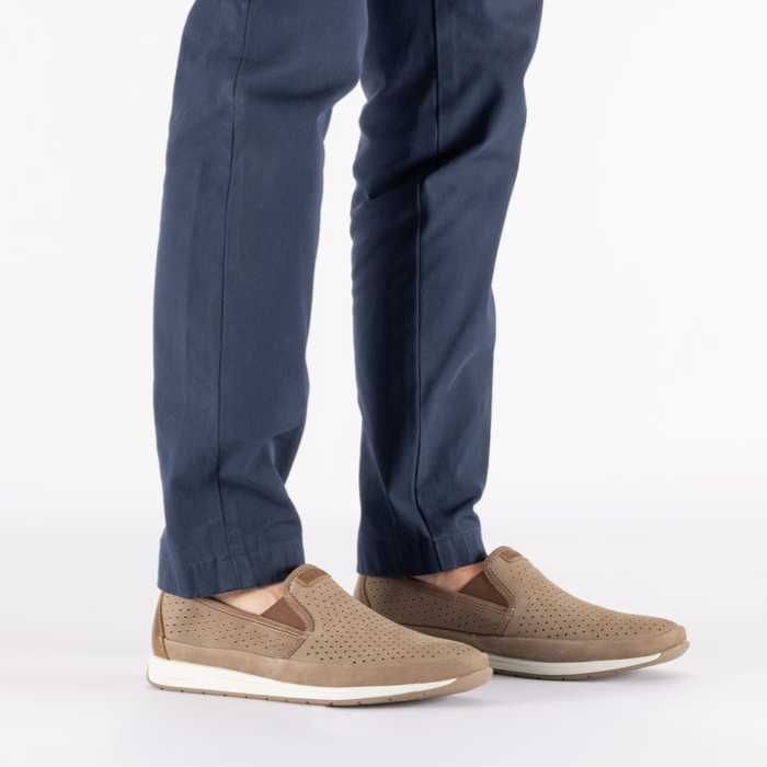 Beige slip-on shoes worn with navy pants.