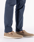 Beige slip-on shoes worn with navy pants.