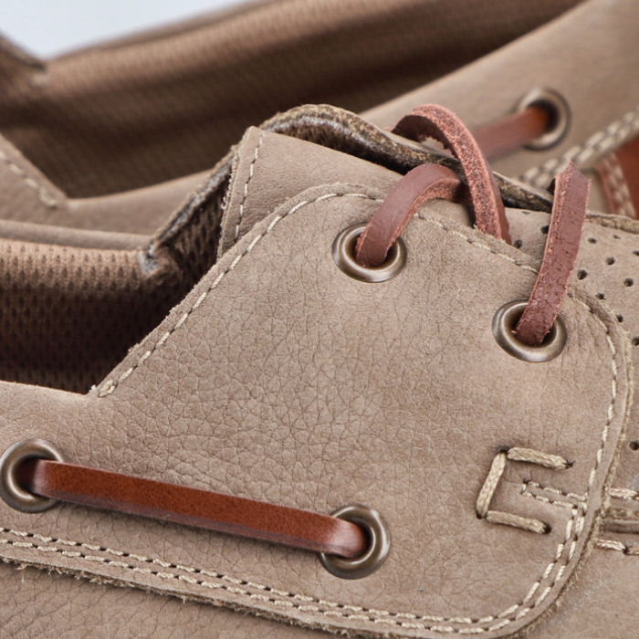 Close-up of a brown leather shoe with laces and stitching detail.