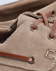 Close-up of a brown leather shoe with laces and stitching detail.
