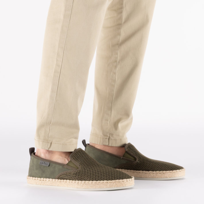 Person wearing green mesh espadrilles with beige pants.