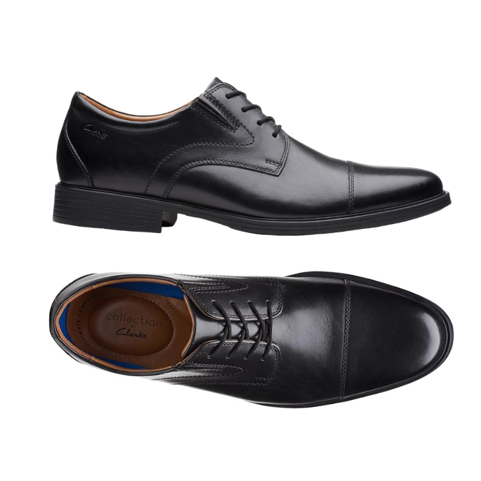 Pair of Black leather derby dress shoes with stitching details, tan Clark's logo'd footbed and low heel. 