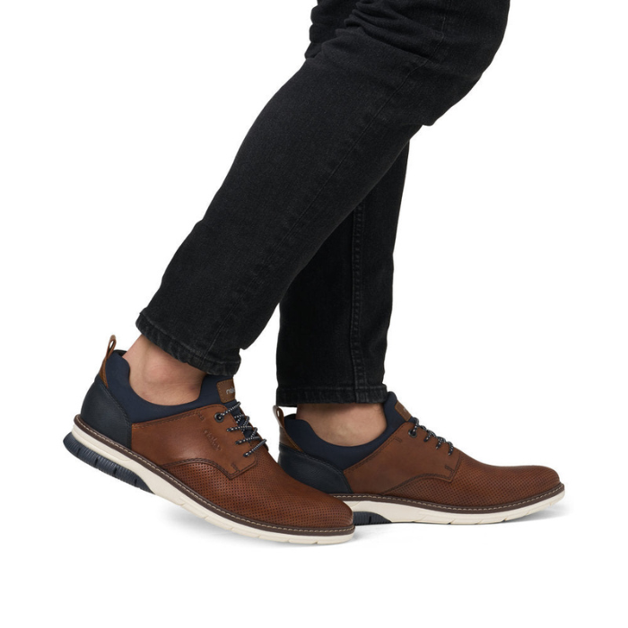 Brown slip on perforated leather shoes worn with black jeans.