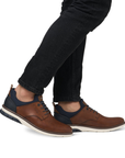 Brown slip on perforated leather shoes worn with black jeans.