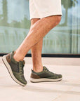 Model wearing green Sneakers and beige shorts in a casual outdoor setting.