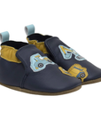 Pair of navy blue baby shoes with yellow accents and construction vehicle's on toe, cinched cuff and blue pull tab.