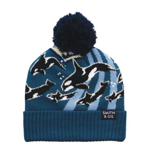 Blue knit beanie with orca whale pattern and pom-pom on top.