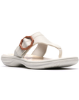 White thong sandal with a brown octagonal buckle, floral beige footbed and white outsole.