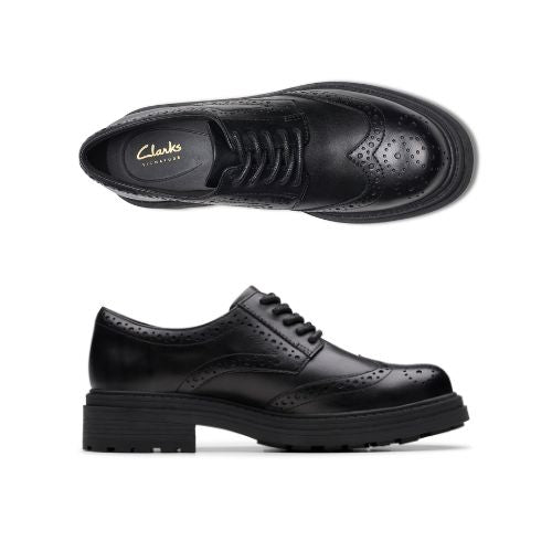 Pair of black leather Oxford lace shoes with a chunky rubber outsole and intricate baroque details.