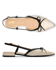 Pair of Pointed-toe slingback flats with black bow detail, cream upper, Clarks logo'd footbed and a low block heel.