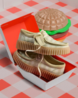 Sage platform sneakers displayed in hamburger box on picnic table cloth and hamburger decor beside it.