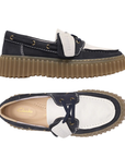 Pair of Navy and white boat shoes with a tan Clarks logo'd footbed and  thick brown ribbed outsole.