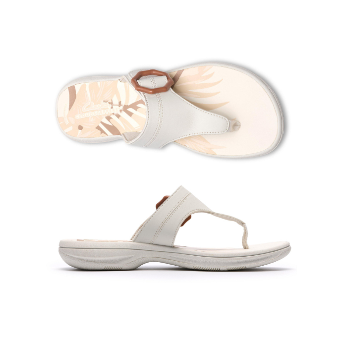 Pair of White thong sandals with a brown octagonal buckle, floral beige footbed and white outsole.