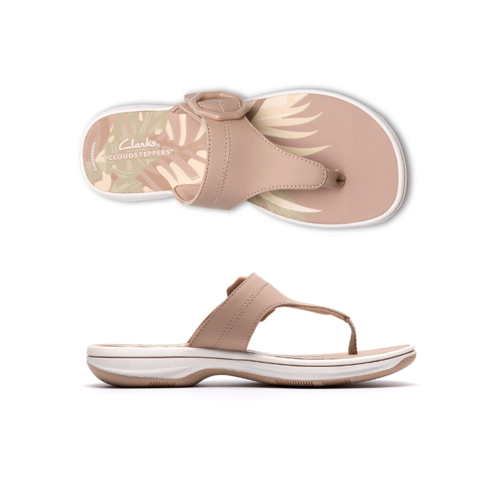 Pair of Beige thong sandals with a tan octagonal buckle, floral beige footbed, white midsole and beige outsole.