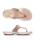 Pair of Beige thong sandals with a tan octagonal buckle, floral beige footbed, white midsole and beige outsole.