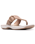 Beige thong sandal with a tan octagonal buckle, floral beige footbed, white midsole and beige outsole.