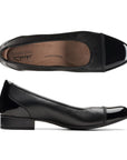Black leather flat with patent toe and heel accents with low stacked heel. Clarks logo printed on brown insole.