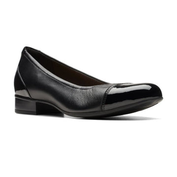 Black leather flat with patent toe and heel accents with low stacked heel.