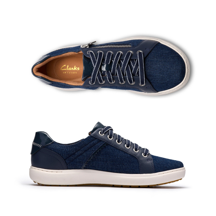 Pair of Denim sneakers with silver side zipper, navy laces, Clarks logo'd tan footbed, white midsole and brown outsole.