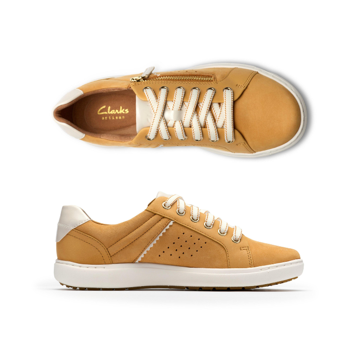 Pair of Yellow sneakers with gold side zipper, white laces, white heel accent, Clarks logo'd tan footbed, white midsole and brown outsole.