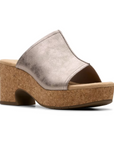 Clarks Nerisa Vine Heeled Sandal in metallic silver with cork midsole, perfect for elevating casual or evening outfits.