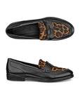 Pair of feminine black leather penny loafers with a closed toe, leopard print accent on instep, strap across the foot and black Ecco logo'd footbed.