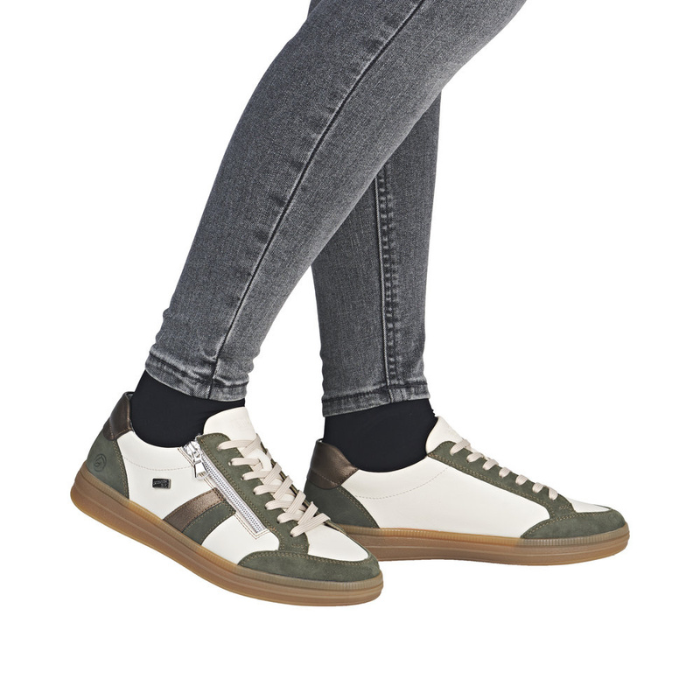 Green and white lace & zipper sneakers worn with gray jeans.