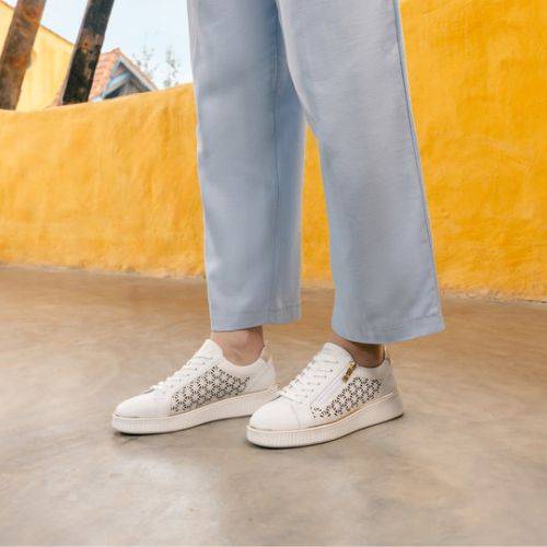 Outdoor scene with model in white Remonte D2E03 sneakers, showcasing breathable leather and casual fashion appeal.