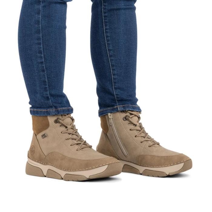 Beige lace boots worn with blue jeans.