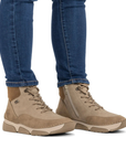 Beige lace boots worn with blue jeans.