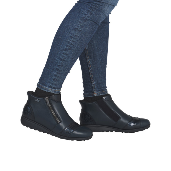 Black ankle boots worn with blue jeans.