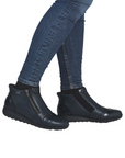 Black ankle boots worn with blue jeans.
