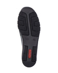 Black rubber outsole of women's wedge shoe with red Rieker logo on heel.