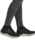 Black sneakers with plaid accents worn with gray jeans.