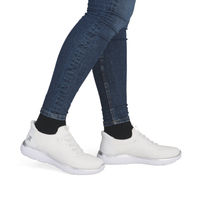 White sneakers worn with blue jeans.