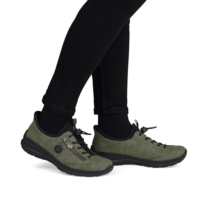 Green sneakers worn with black pants.