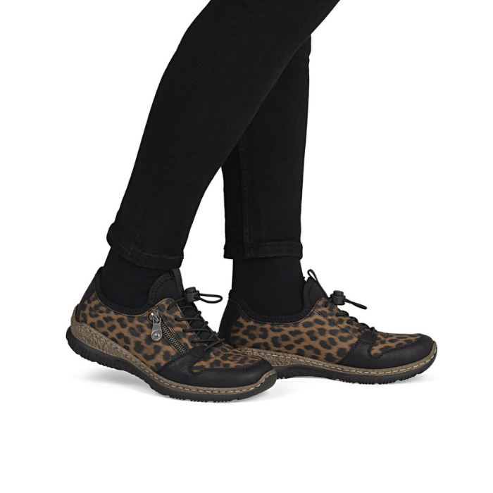 Leopard print bungee lace shoes worn with black pants.