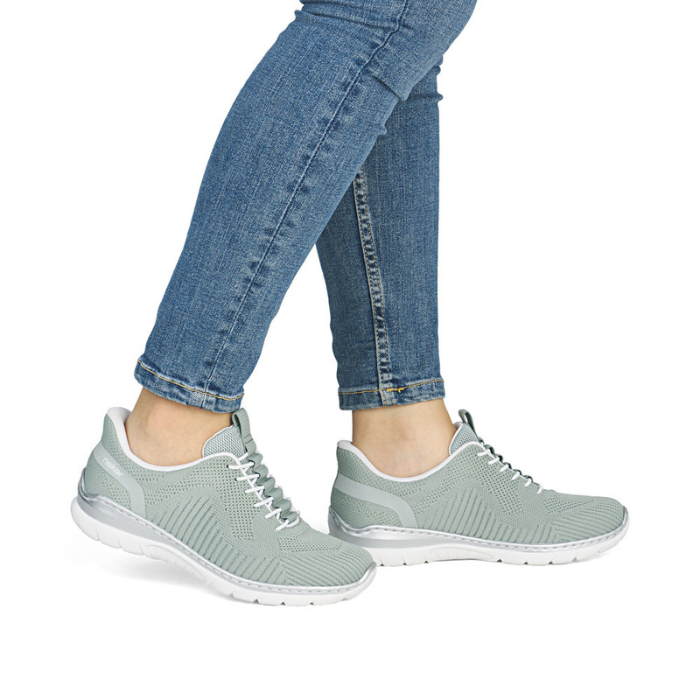 Light green slip-on sneakers worn with blue jeans.