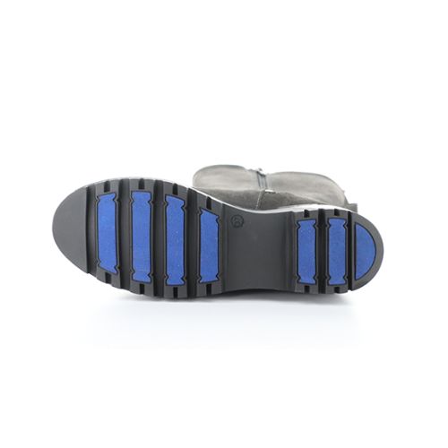 Aggressive treaded outsole of winter boot with blue fiber glass plug lines.