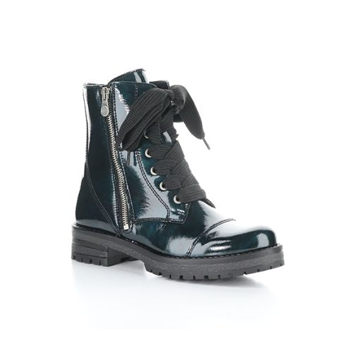 Dark green patent leather combat boot with oversized black lace bow, side zipper and treaded outsole.
