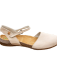 Beige closed toe sandal with a Velcro strap and brown speckled foot.