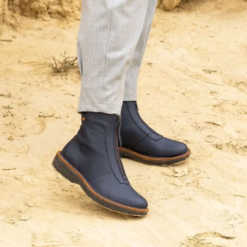 Black mid boots with front zipper worn in desert with grey khaki pants.