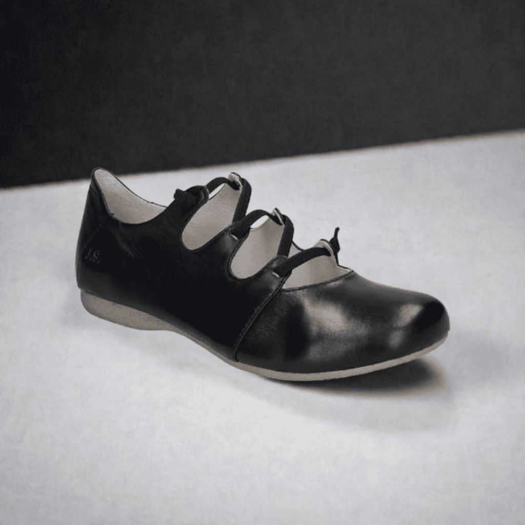Josef Seibels Fiona 04: Black slip-on flat with crisscross straps and a durable rubber outsole.
