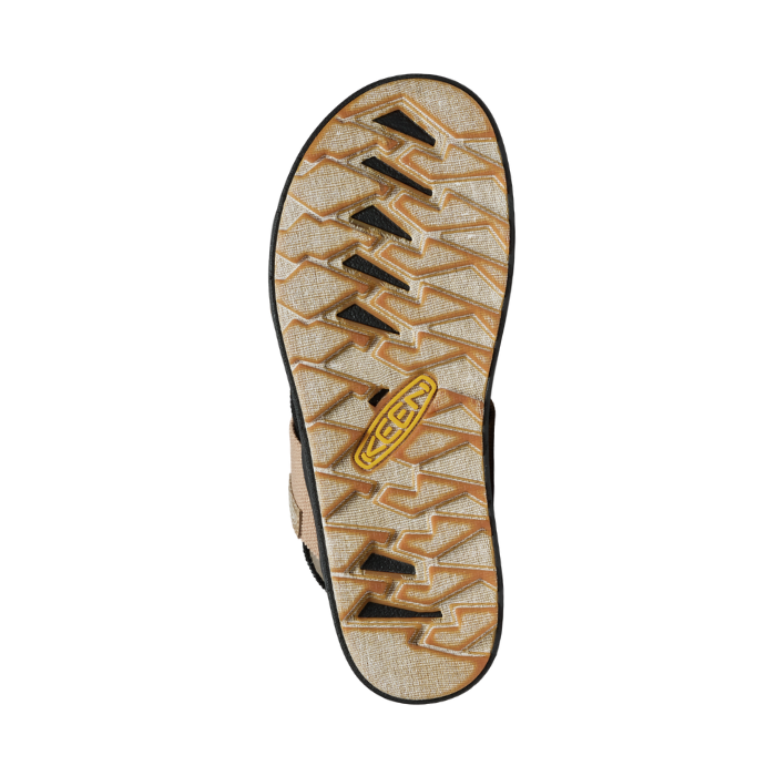 Beige geometric patterned outsole with distressed dark brown accents and yellow Keen logo in middle.