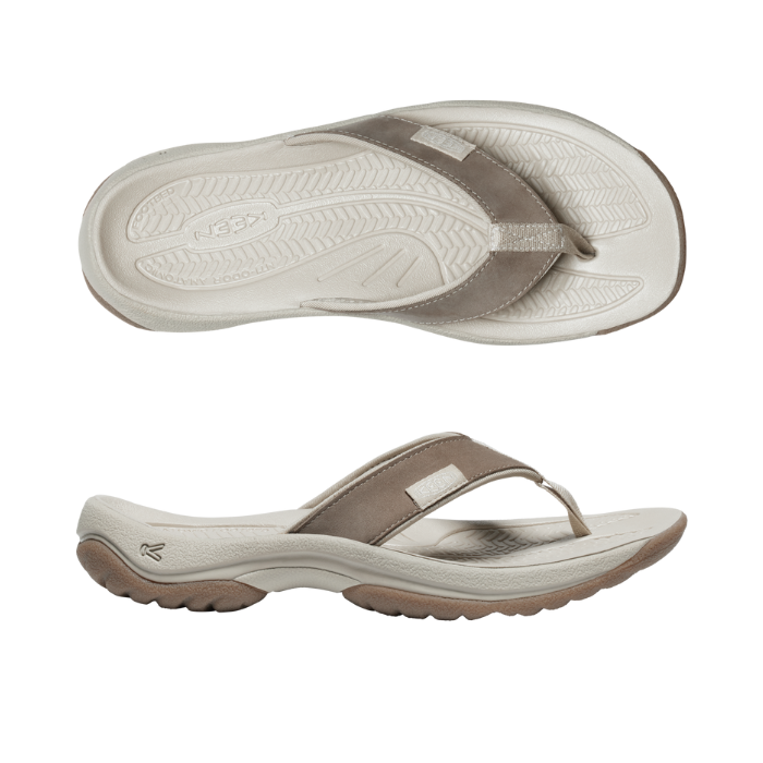 Pair of beige thong sandals with white textured footbed and rugged outsole.