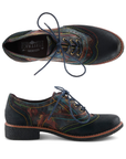 A pair of Oxford shoes with dark navy toe cap and heel, a painterly floral patterned leather upper in red, orange, green, and blue tones, blue waxed laces and rainbow stitching accents.