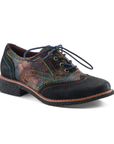 An Oxford shoe with dark navy toe cap and heel, a painterly floral patterned leather upper in red, orange, green, and blue tones, blue waxed laces and rainbow stitching accents.