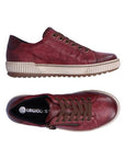 Pair of A red leather lace-up sneaker with a zipper on the side, black Remonte logo'd footbed, an off-white midsole and brown outsole.