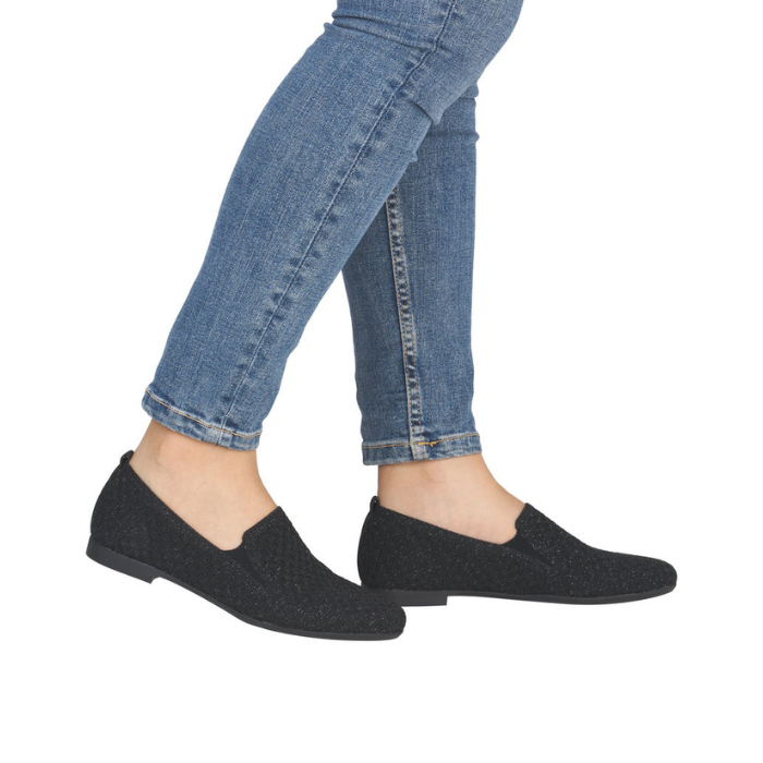 Black glittery loafers worn with blue jeans.