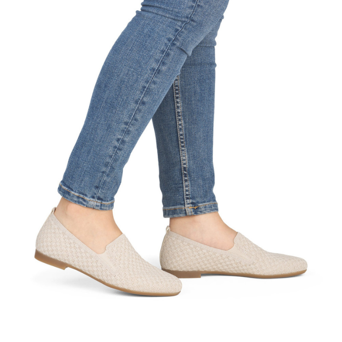 Beige woven flats worn with blue jeans.